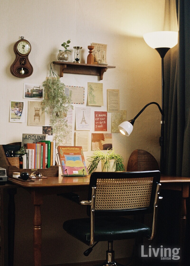 엽서, 아날로그 시계, 원목 매거진 랙이 조화를 이루는 작업실 겸 서재.