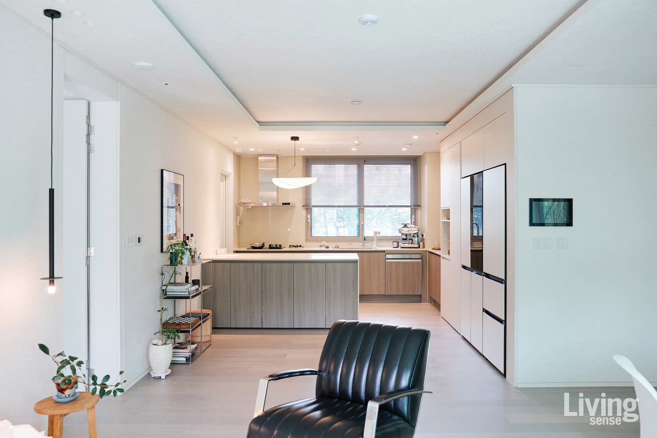 우드가 더하는 온기와 간결한 선의 조화가 돋보이는 주방. 불필요한 것을 덜어낸 덕분에 일상에 여백과 평온을 더한다.