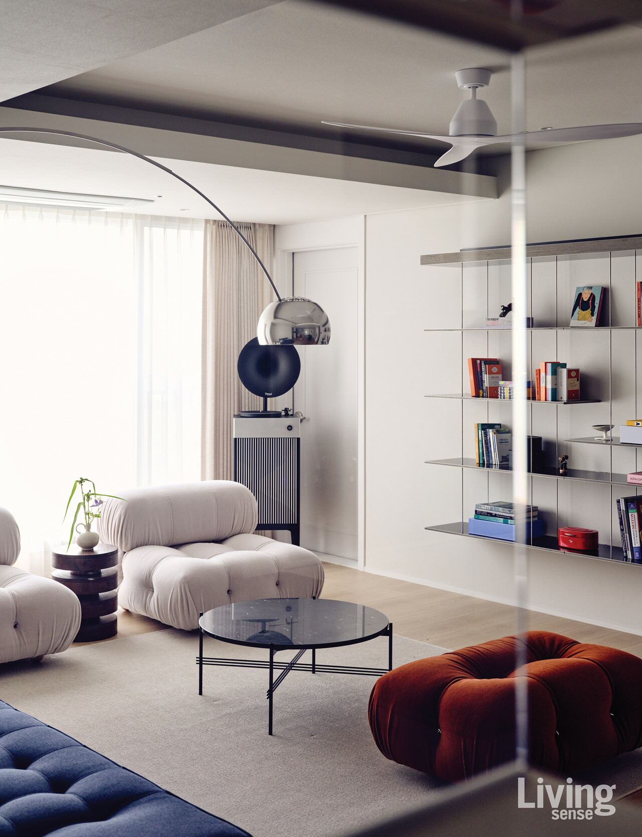 거실에는 TV 대신 장 누벨이 디자인한 몰테니&씨Molteni&C의 그레듀에이트Graduate벽선반을 설치했다. 플로스Flos의 아르코ARCO플로어 램프가 공간에 개성을 더한다. 비앤비 이탈리아B&B Italia의 카멜레온다Camaleonda소파는 주방을 향해 배치했다.