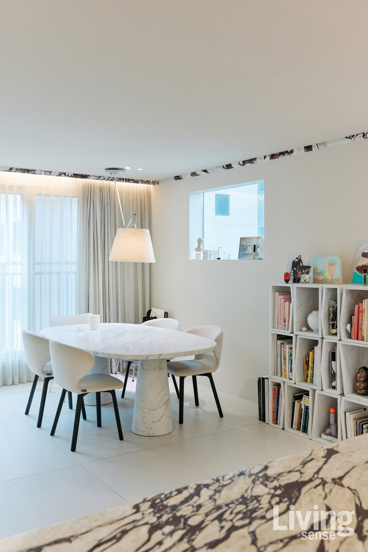 대리석 상팜과 이를 지탱하는 2개의 다리로만 구성된 아가페카사Agapecasa의 에로스 테이블이 놓인 거실.