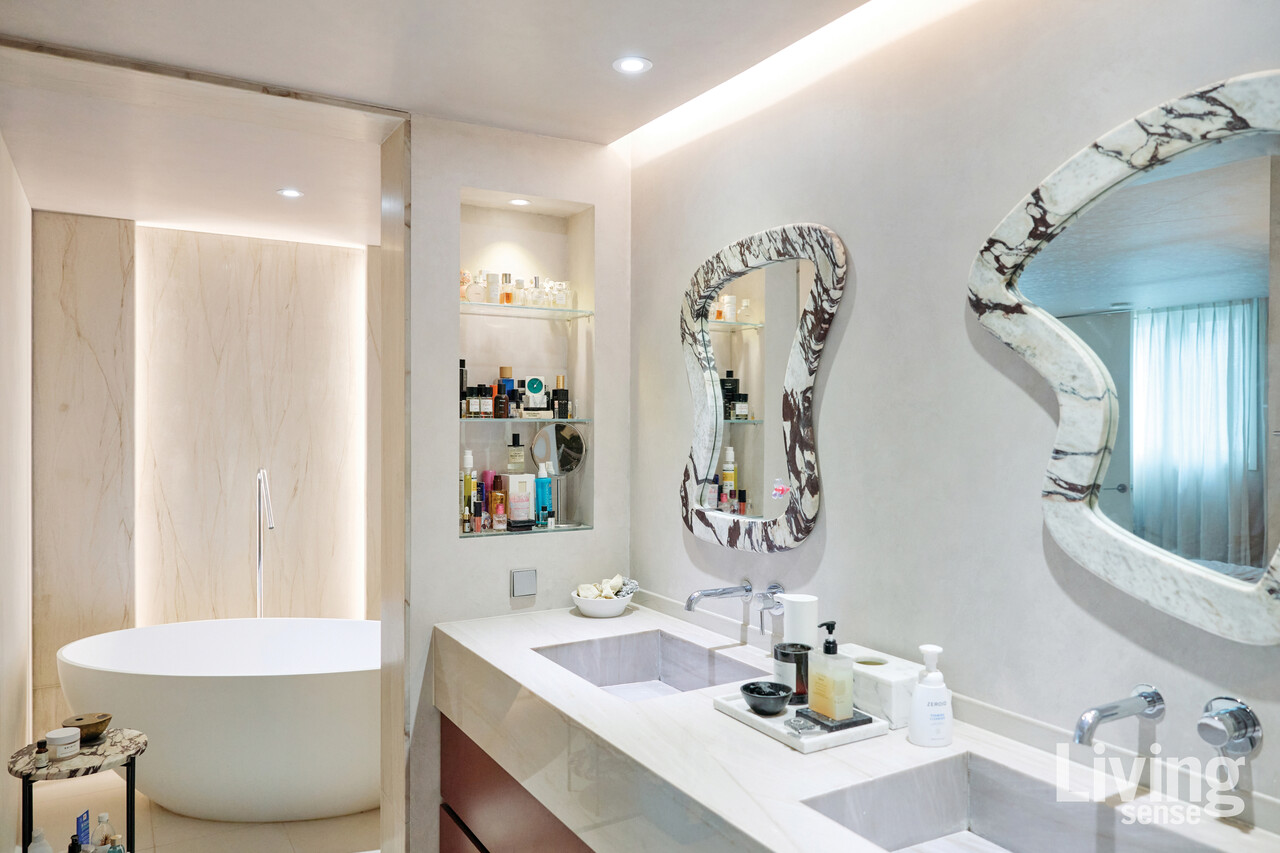  직접 디자인에 참여한 대리석 거울과 큼직한 욕조, 자투리 대리석으로 만든 사이드 테이블로 꾸민 욕실.