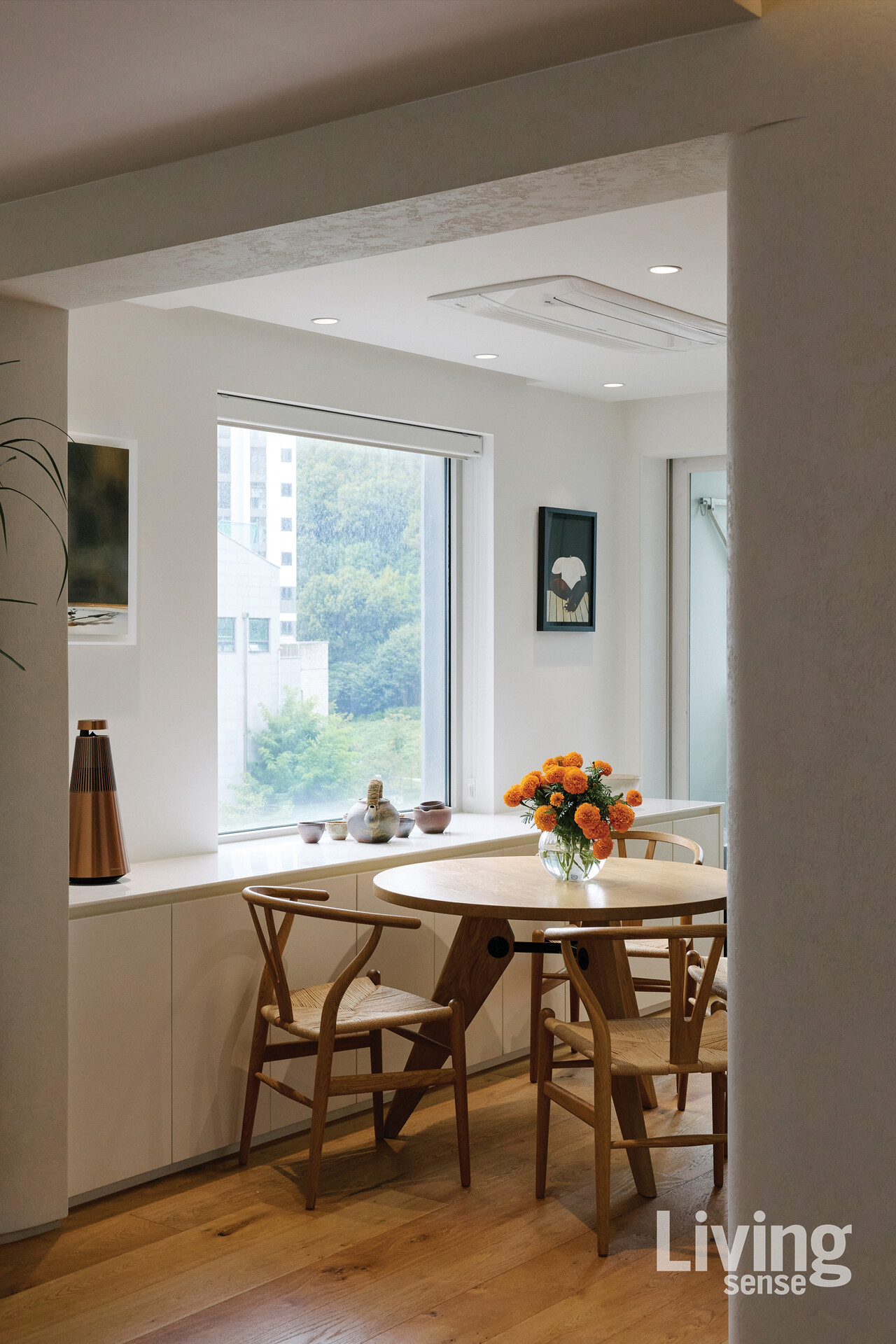 주방에는 비트라Vitra의 게리동Guéridon 다이닝 테이블과 칼한센앤선의 위시본 체어를 매치했다. 벽면에는 이석주 작가와 아프리카계 작가 바하티 시모엔스Bahati Simoens의 작품을 나란히 걸었고, 선반에는 이인진 작가의 도자기 찻잔 세트를 두었다.